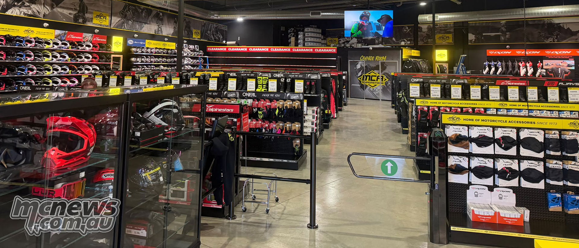 Entrance to MCA Superstore Canberra, with a glass helmet cabinet, off-road helmet displays and riding gear aisles.