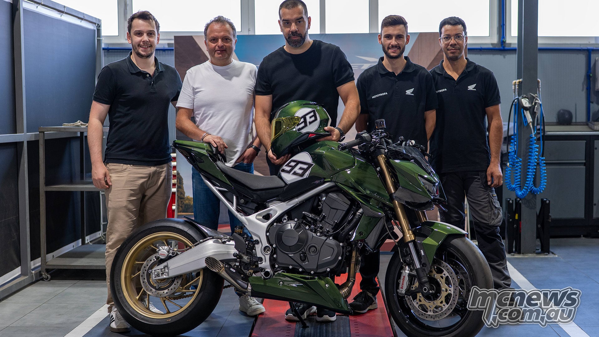 Five members of the Mototrofa team standing behind their green Mugen Honda CB750 Hornet in the workshop