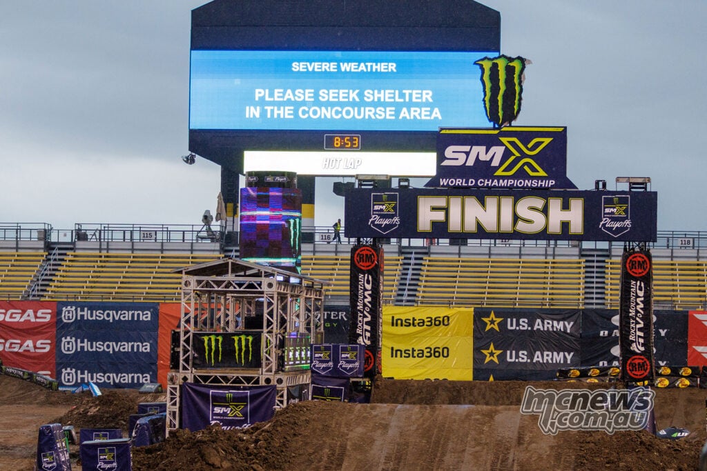 Stadium screen above the SMX finish line displaying a severe-weather warning and instructions to seek shelter.