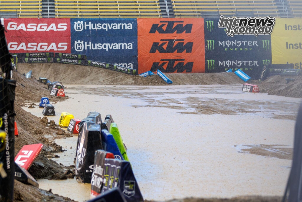 Standing water covers a broad section of the Columbus SMX track, with track markers lining the flooded edges.