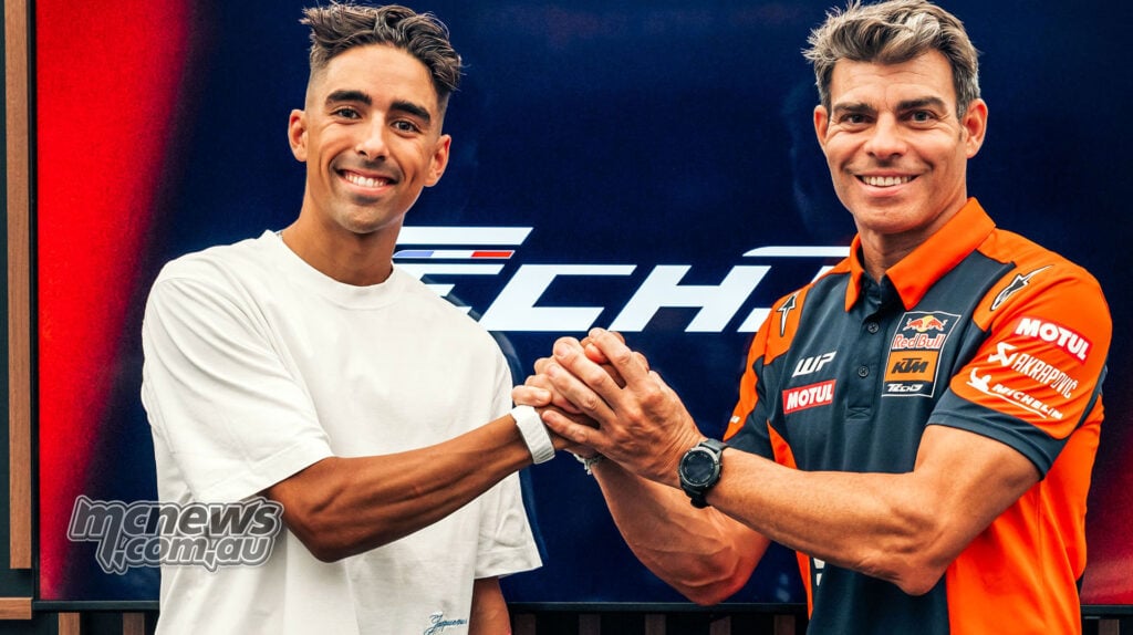 Senna Agius and Tech3 Team Manager Nicolas Goyon shake hands in front of the team’s logo.