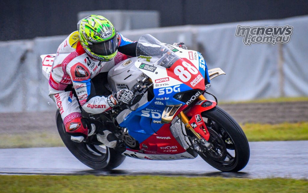 Ryo Mizuno corners on the number 88 Team Kagayama Ducati Panigale V4 R on a wet track.