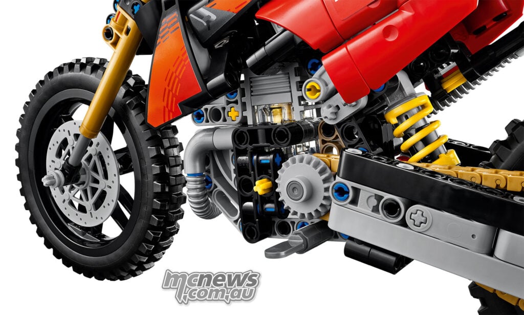 Close-up of the LEGO Ducati's engine mechanism, gold chain, front wheel and yellow rear suspension spring.