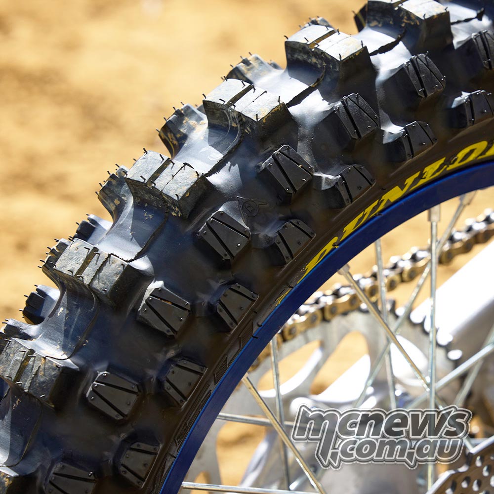 Detailed close-up of the Dunlop Geomax MX54 rear tyre tread, highlighting large centre knobs and smaller block-within-a-block shoulder elements.