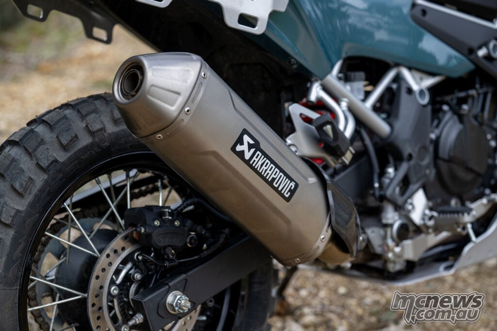 Akrapovič titanium silencer beside the knobbly rear tyre and spoked wheel of the modified Kawasaki KLE500 SE.