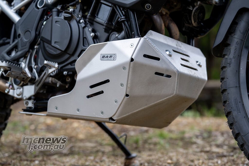 Low-angle view of the B&B aluminium bashplate fitted beneath the Kawasaki KLE500 SE engine and exhaust headers.