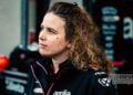 Elena De Cia, Aprilia Racing's Strategy and Data Analysis Lead, pictured in profile wearing Aprilia team clothing in the MotoGP paddock.