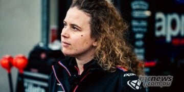 Elena De Cia, Aprilia Racing's Strategy and Data Analysis Lead, pictured in profile wearing Aprilia team clothing in the MotoGP paddock.