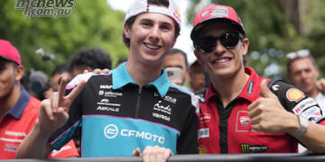 Máximo Quiles, left, makes a peace sign beside Marc Márquez, who gives a thumbs-up, during the 2026 Mandalika rider parade.