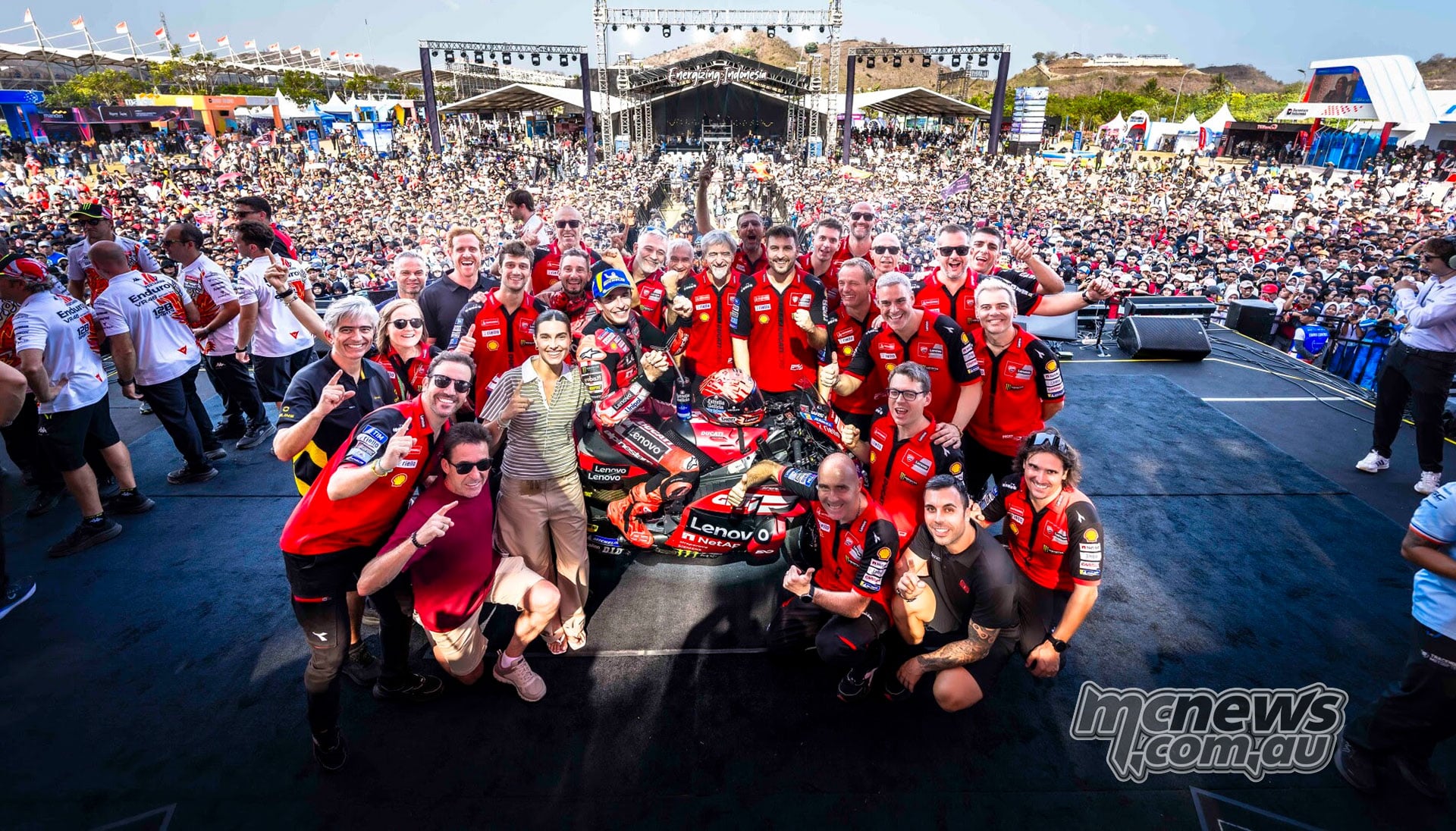 Marc Marquez and the Ducati Lenovo Team celebrate around his Ducati in front of the Mandalika crowd.