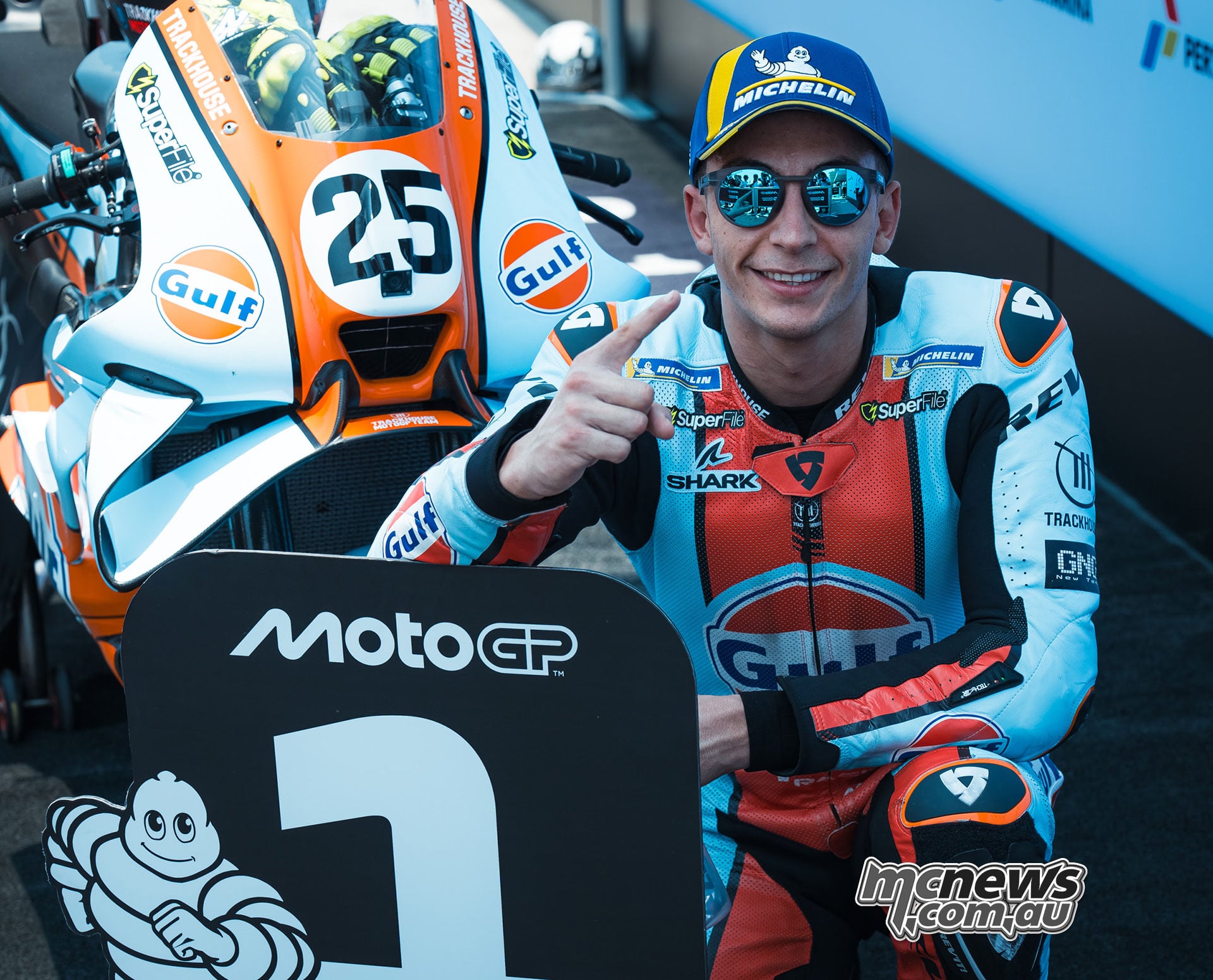 Raul Fernandez poses beside his Gulf-liveried Aprilia and the pole-position board.