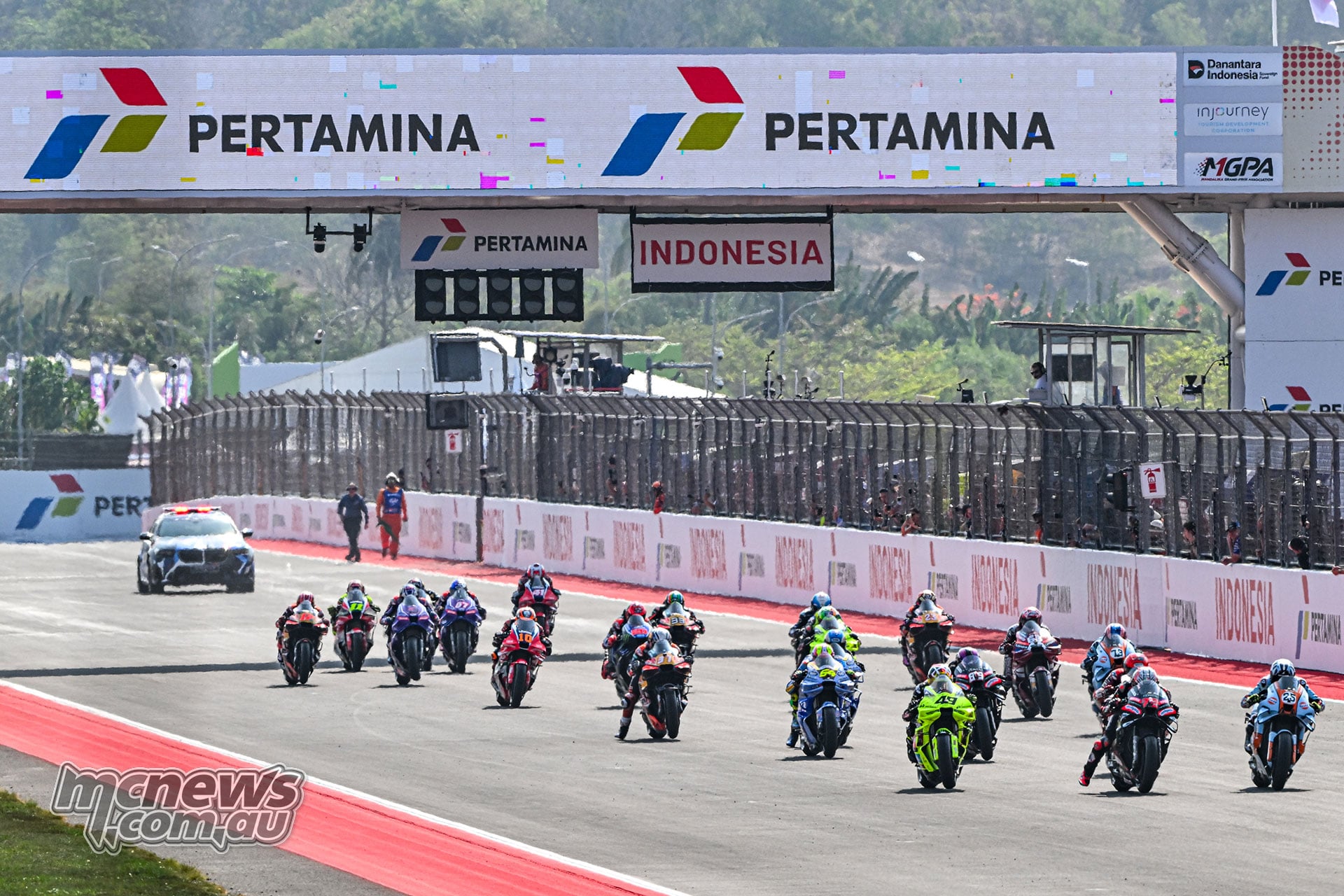 The MotoGP field accelerates towards Turn One at the start of the Mandalika Sprint.