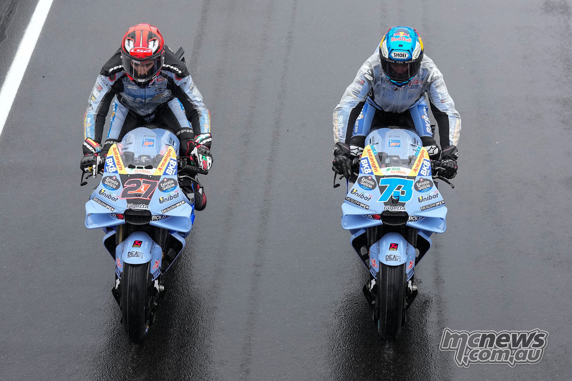 An overhead view of Iker Lecuona on the number 27 Gresini Ducati beside Alex Marquez on the number 73 bike on the wet track.