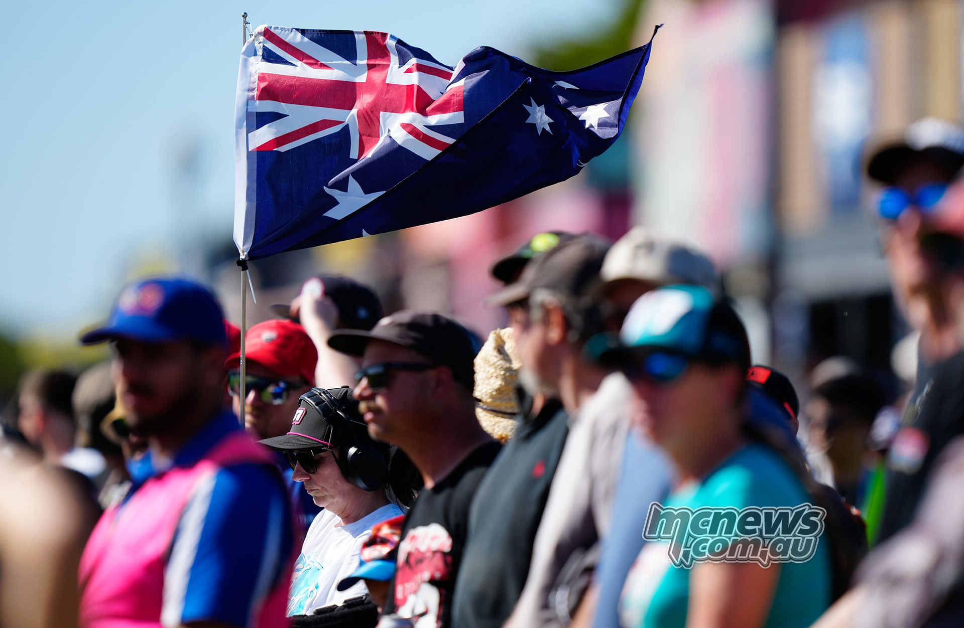 An Australian flag flies above spectators watching the Australian MotoGP at Phillip Island.