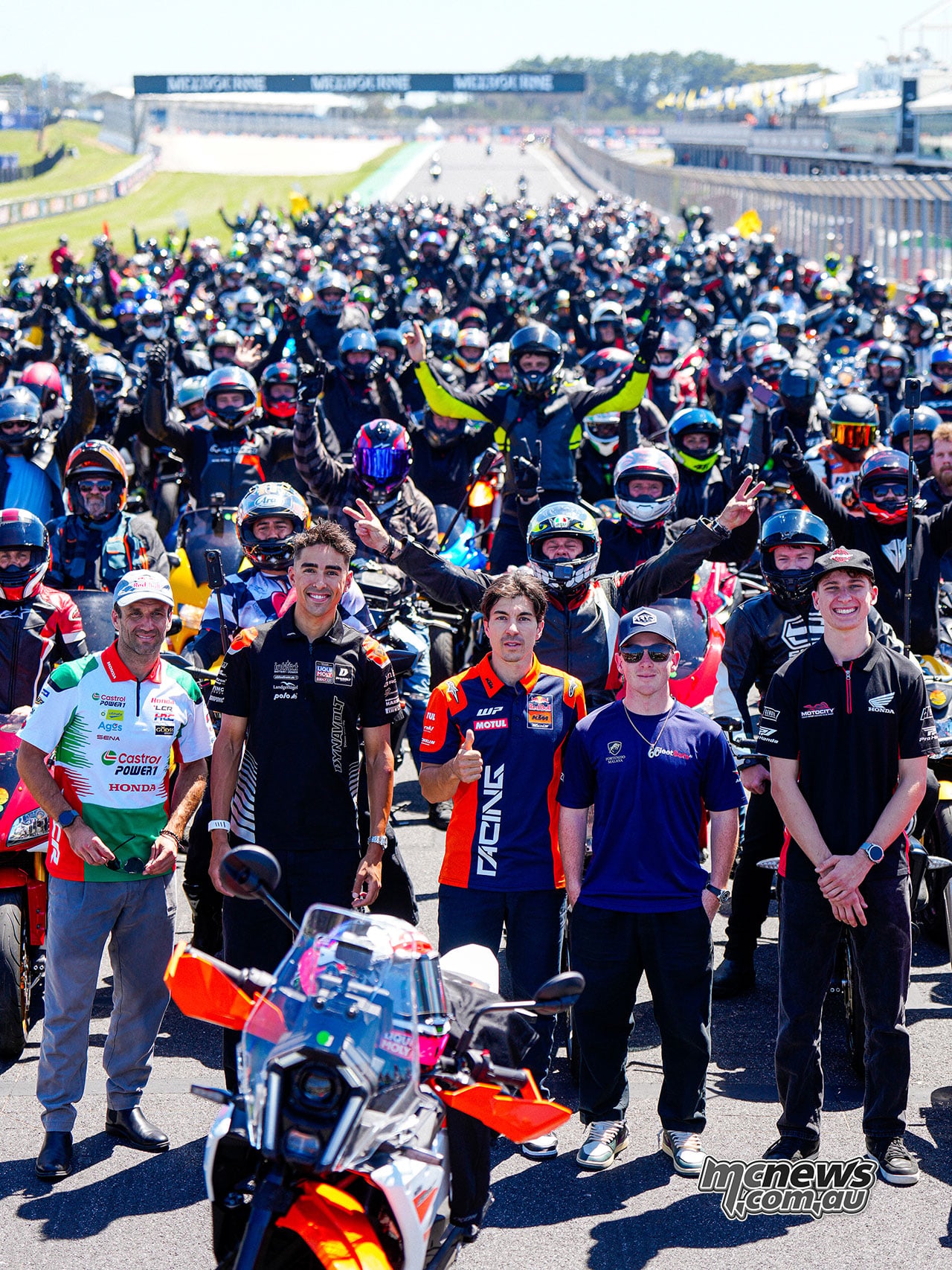 Johann Zarco, Senna Agius, Maverick Vinales, Joel Kelso and Jacob Roulstone pose in front of motorcyclists on Gardner Straight.