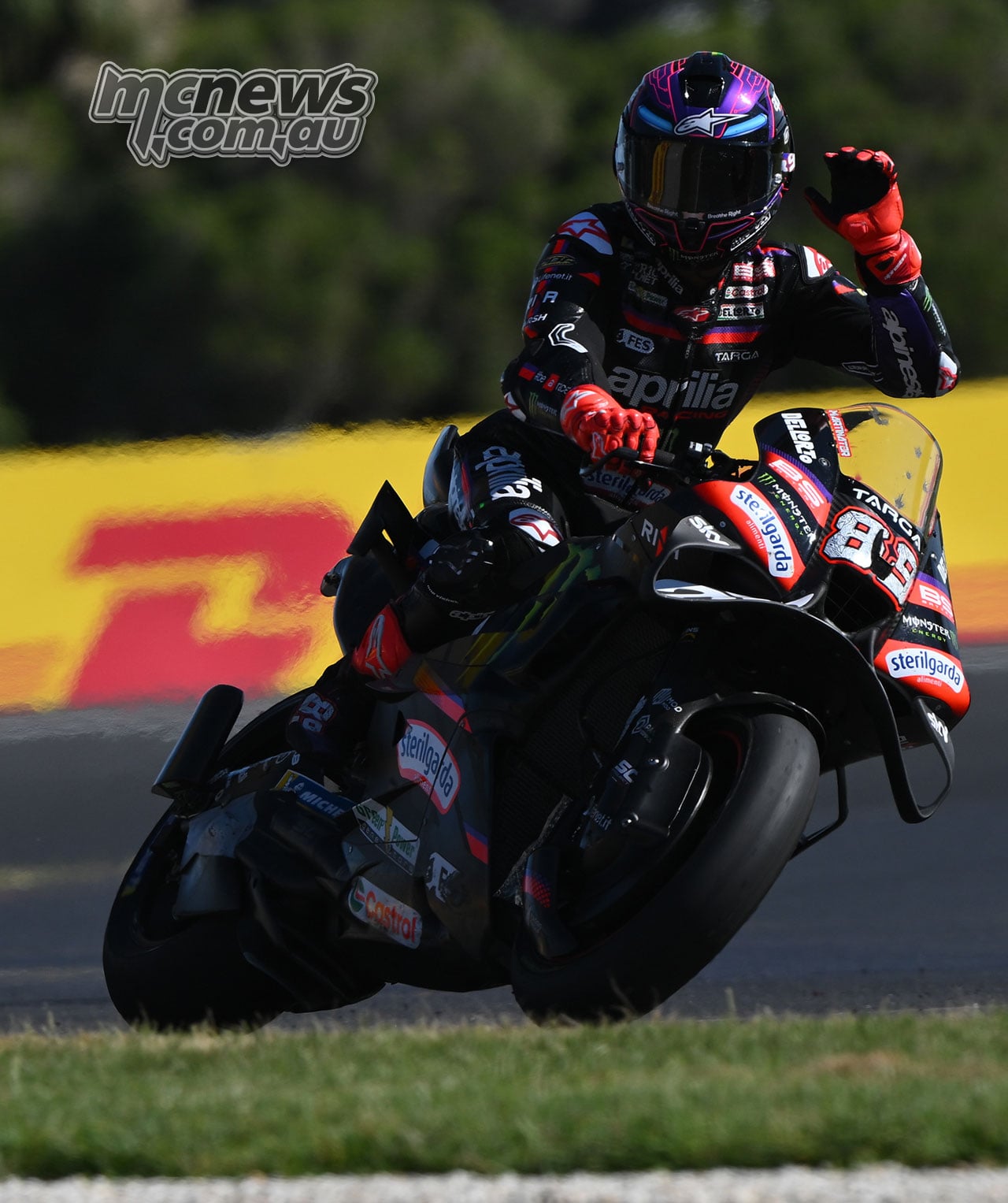 Jorge Martin raises his left hand while riding his number 89 Aprilia at Phillip Island.