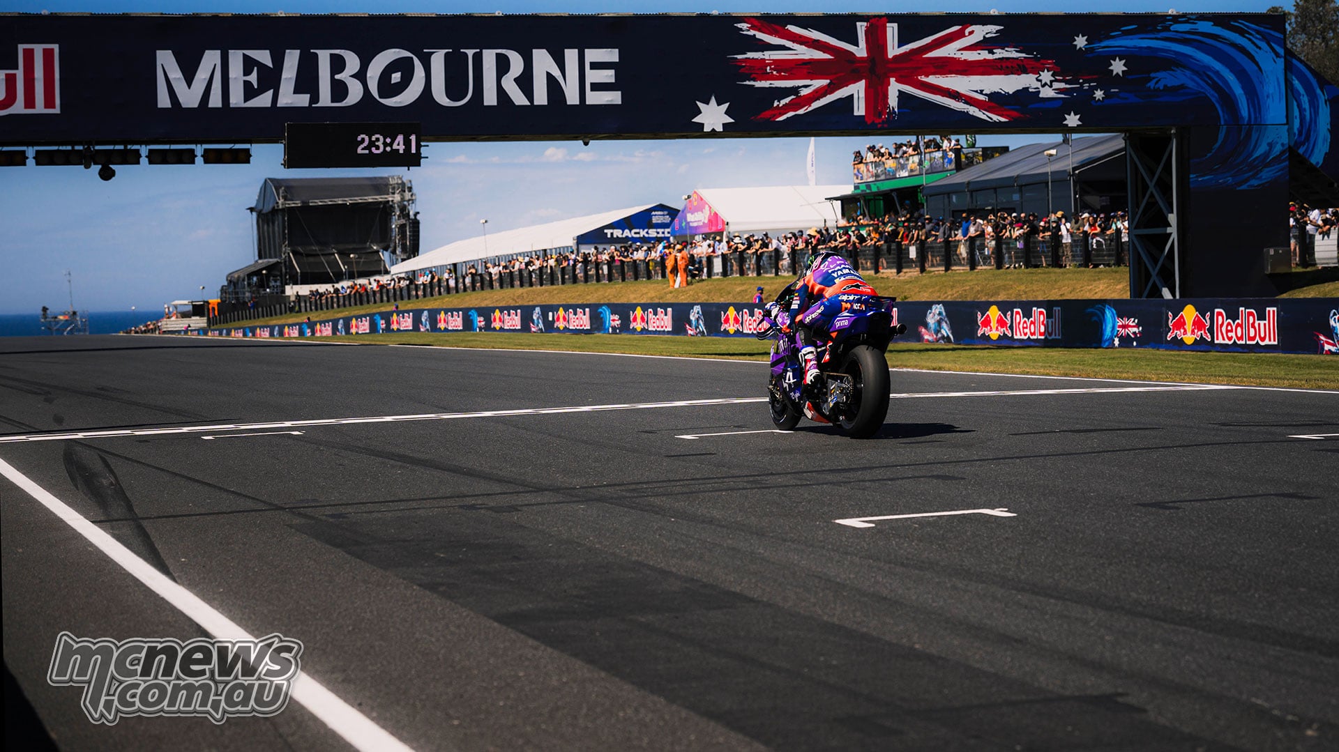 Jack Miller rides his Pramac Yamaha along Gardner Straight beneath the Melbourne bridge and past spectators.