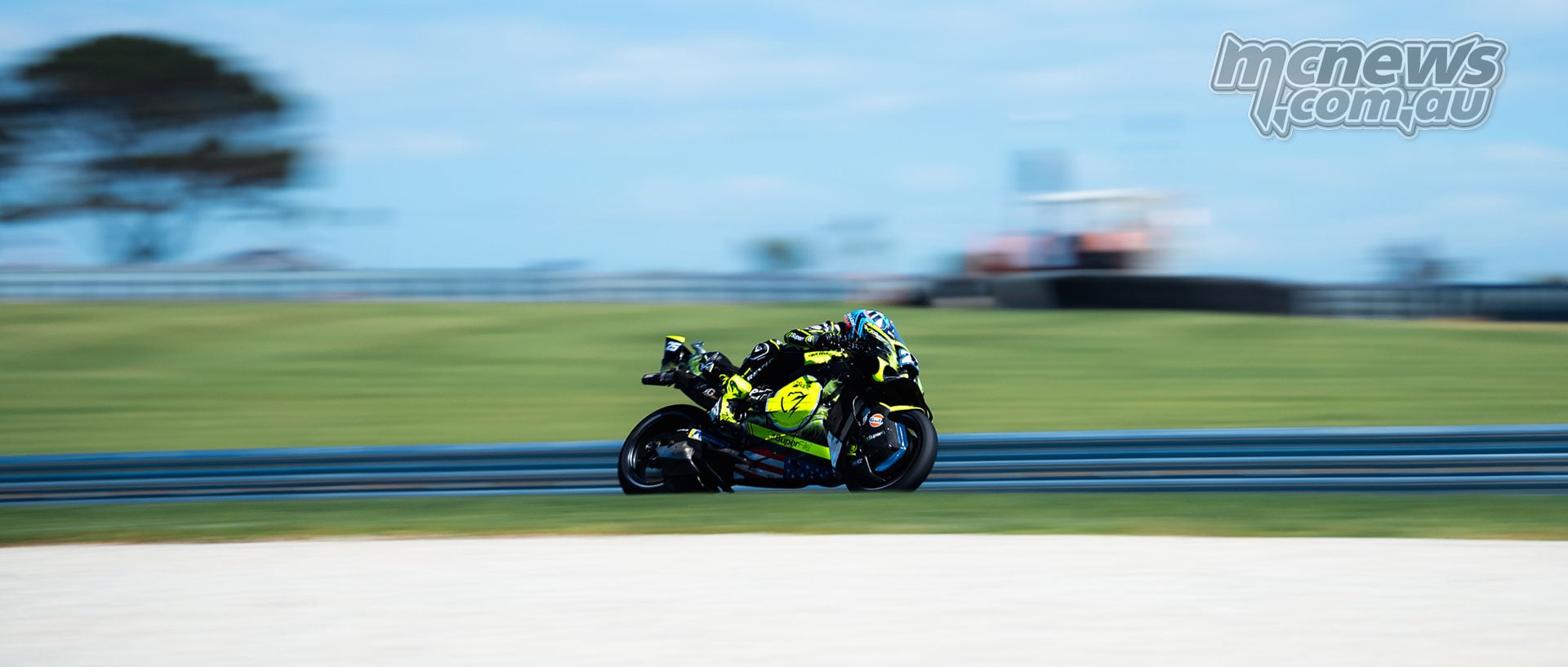 Raul Fernandez rides his yellow and black Trackhouse Aprilia past the barriers at Phillip Island.