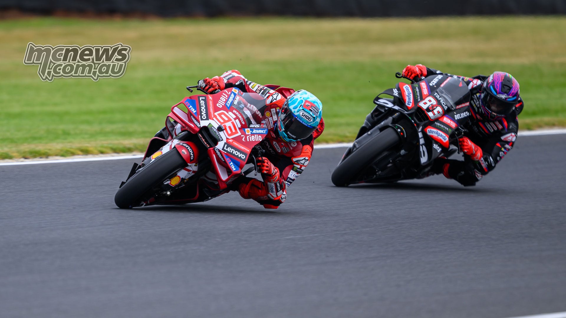 Marc Marquez leads Jorge Martin through a left-hand corner, their red Ducati and black Aprilia leaned low over the track.