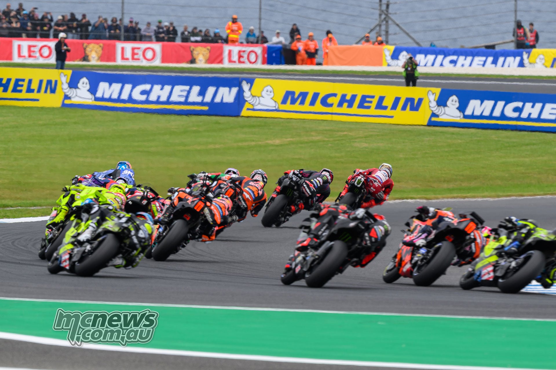 Rear view of the MotoGP field accelerating out of Turn Four, led by Marc Marquez and Jorge Martin.