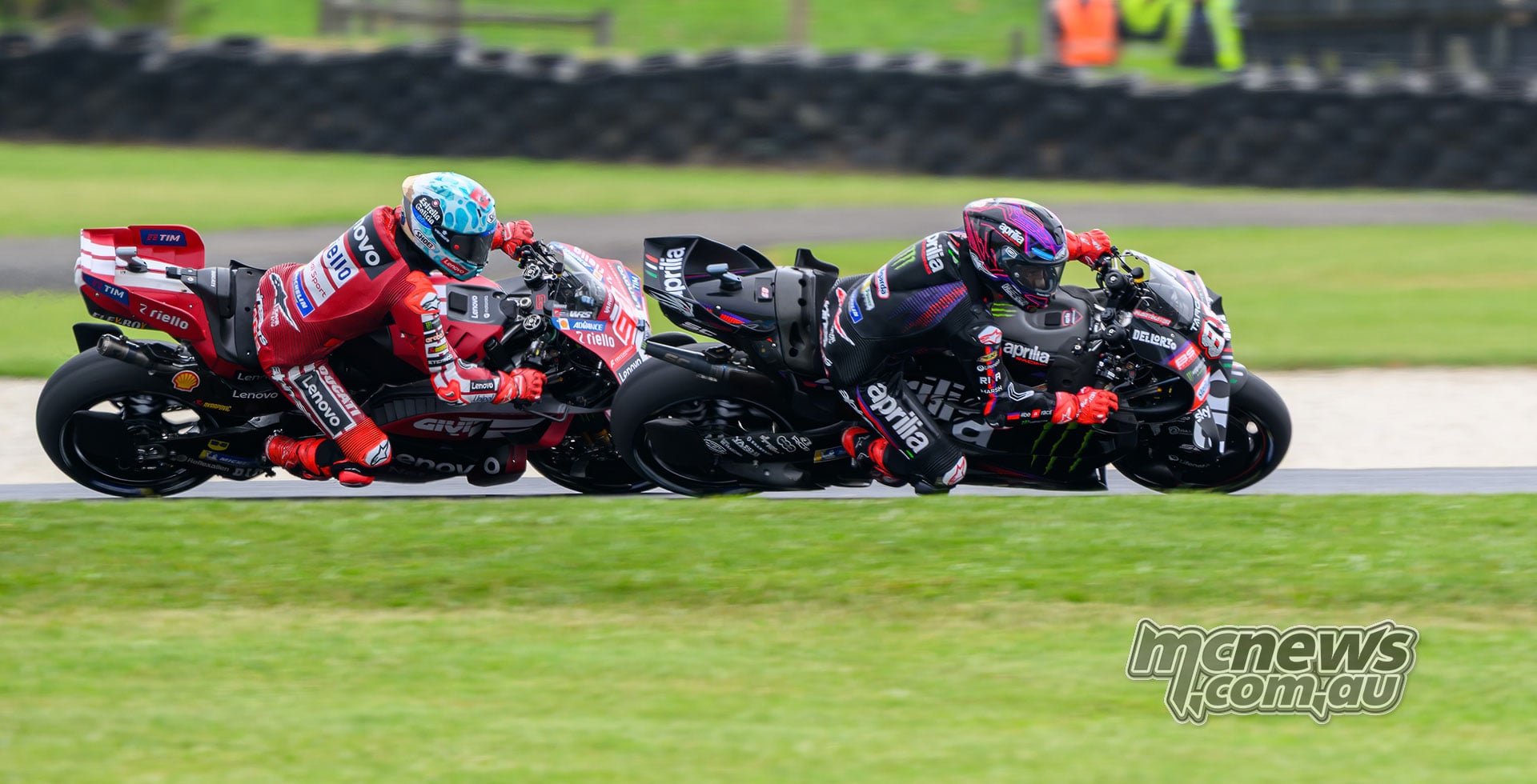 Jorge Martin on his black Aprilia runs alongside Marc Marquez's red Ducati through a right-hand corner at Phillip Island.