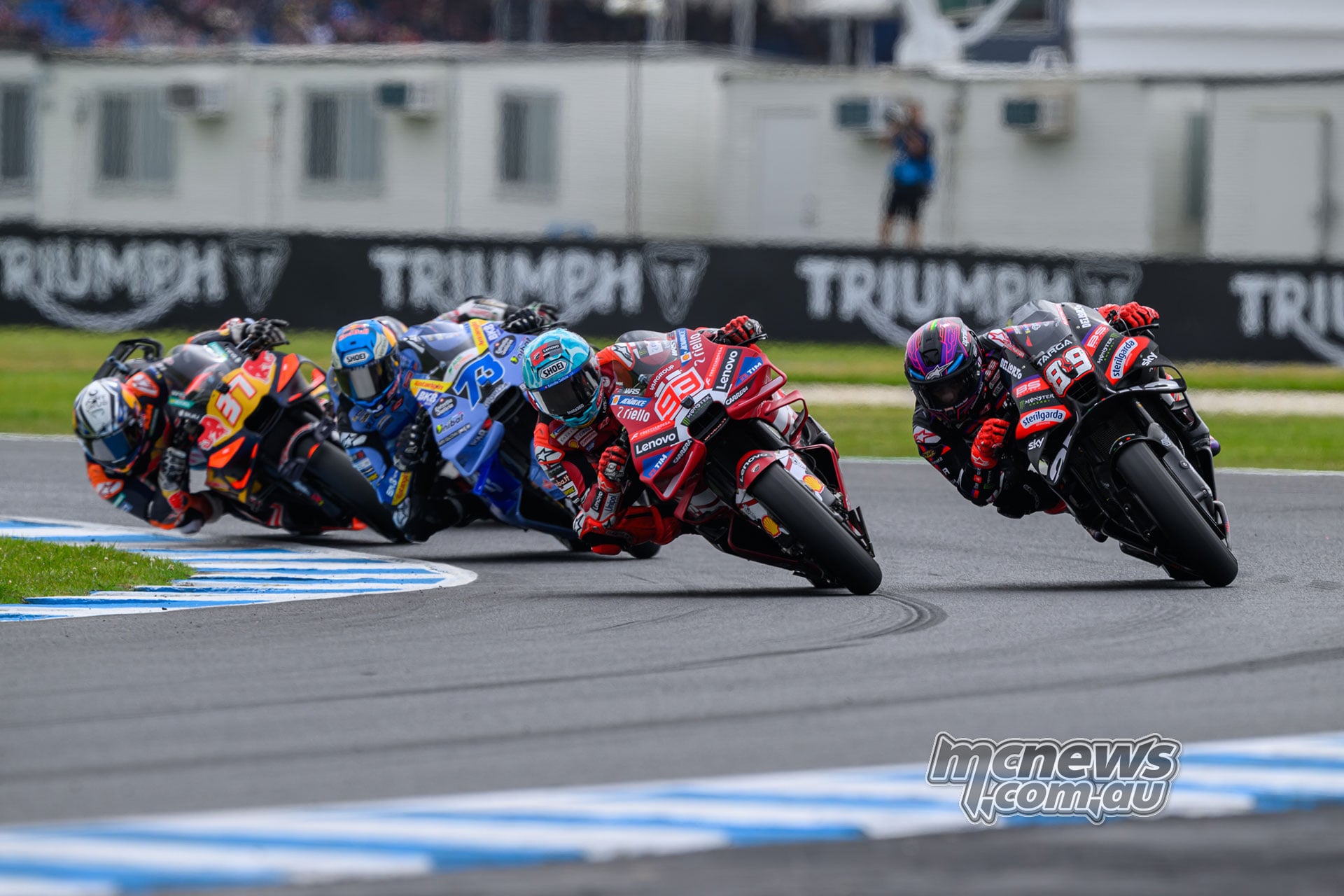 Marc Marquez and Jorge Martin lean side by side out of Turn Four, followed by Alex Marquez and Pedro Acosta.