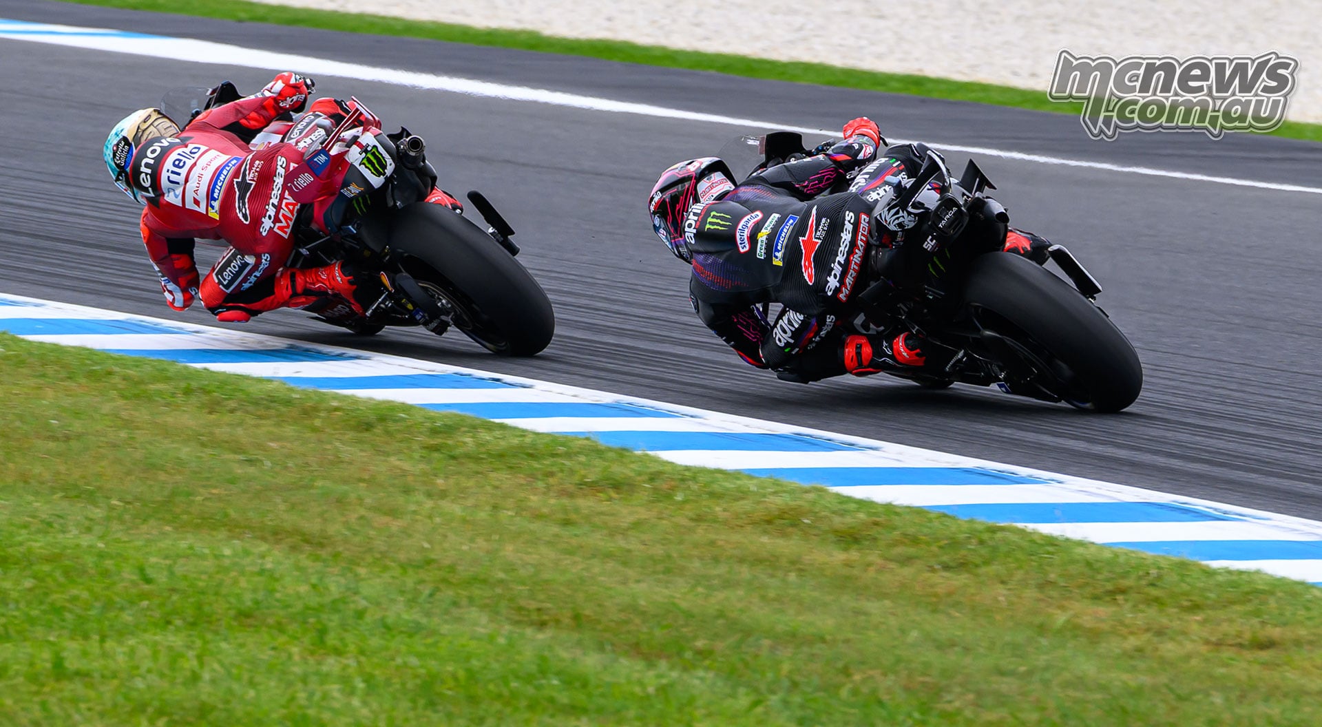 Rear view of Marc Marquez leading Jorge Martin through a left-hand corner beside the blue-and-white kerb at Phillip Island.