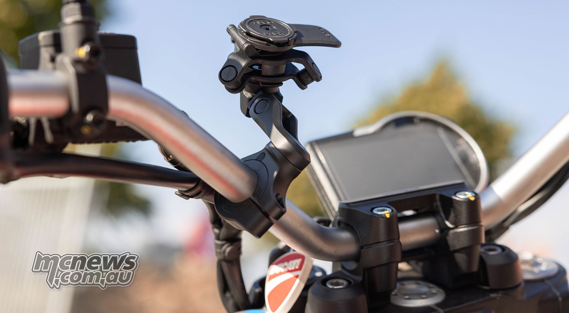 Side view of the Quad Lock Handlebar Mount Pro Adjustable showing its articulated mounting arm and rotating head fitted to a Ducati Scrambler handlebar