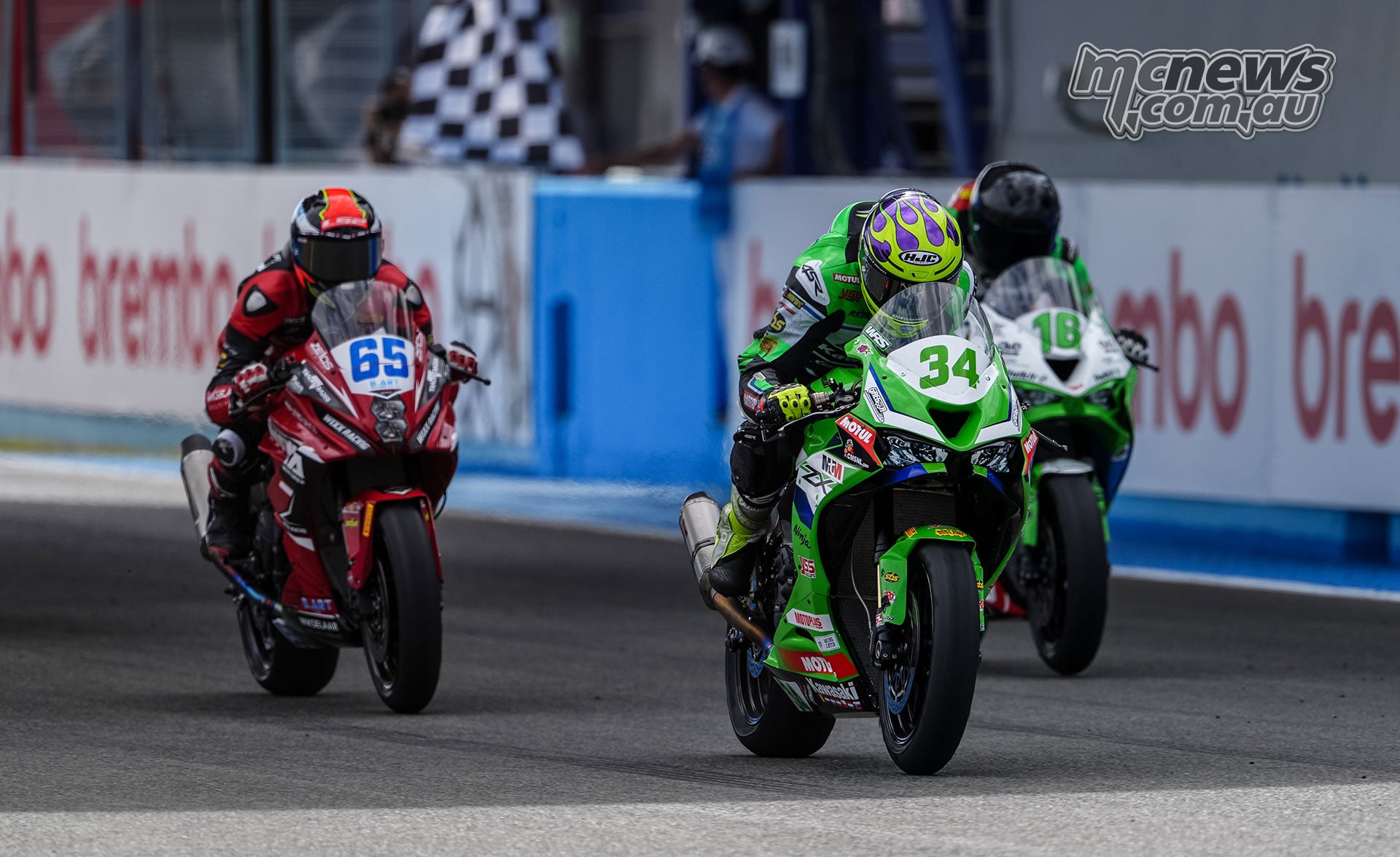 Xavi Artigas on green number 34 Kawasaki crosses the finish line at Jerez ahead of Ferre Fleerackers on Suzuki and Álvaro Fuertes on Kawasaki as the chequered flag waves
