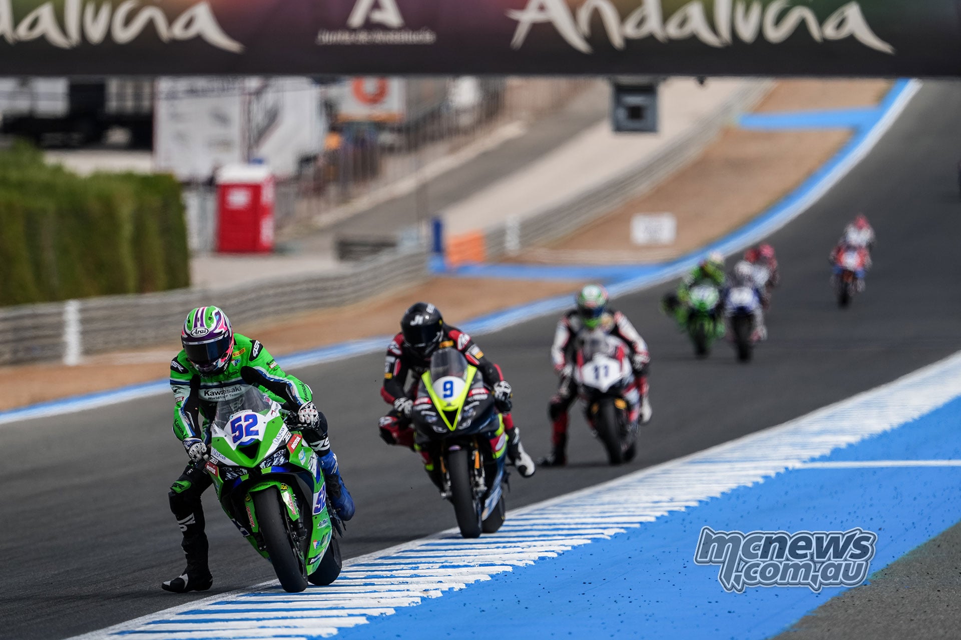Jeremy Alcoba on Kawasaki number 52 leads Jorge Navarro on Triumph number 9 and Matteo Ferrari on Ducati number 11 at Jerez