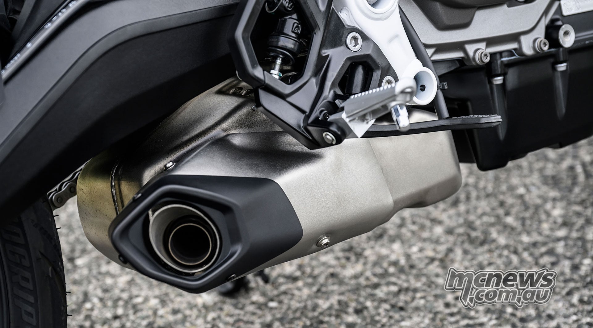 Close-up of the BMW F 450 R stainless-steel underfloor exhaust and muffler.