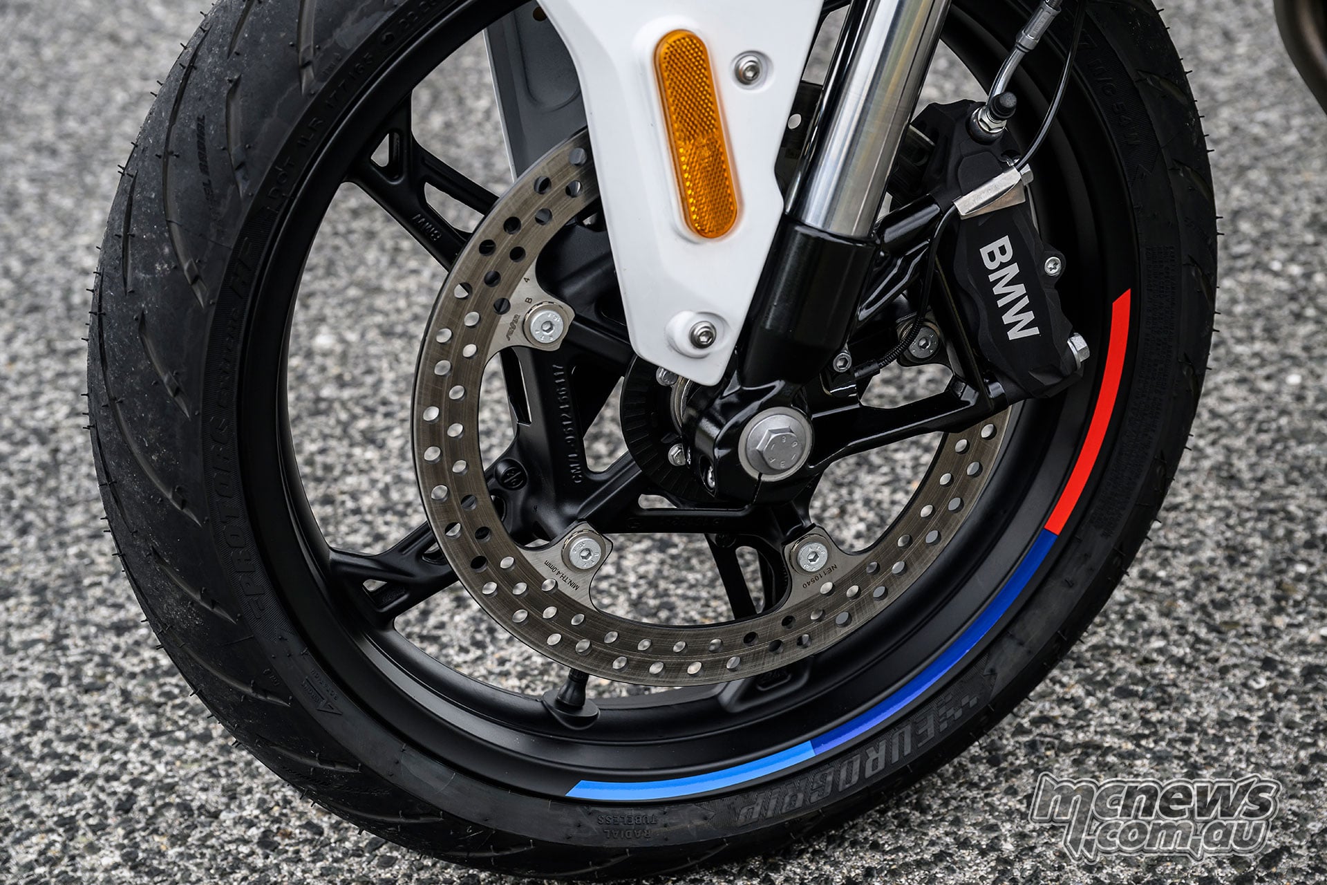 Close-up of the BMW F 450 R front wheel, 310 mm brake disc and Brembo four-piston caliper.