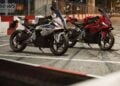 White and red BMW F 450 RR motorcycles parked beside red and white barriers at night