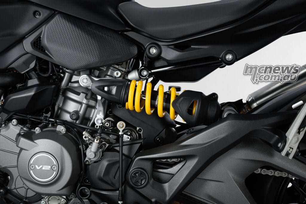 Left-side close-up of the Monster V2 engine, yellow Showa shock spring and aluminium swingarm