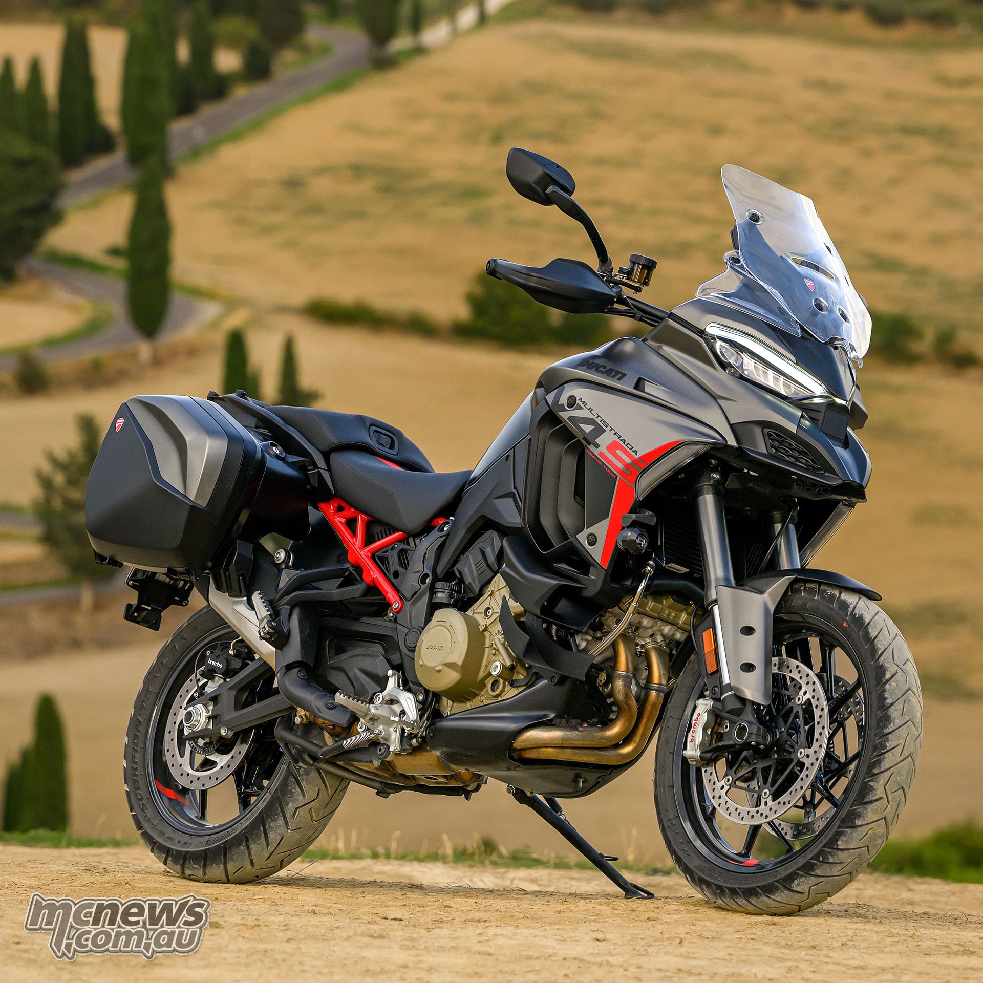 2027 Ducati Multistrada V4 S Grand Tour parked against a Tuscan countryside backdrop