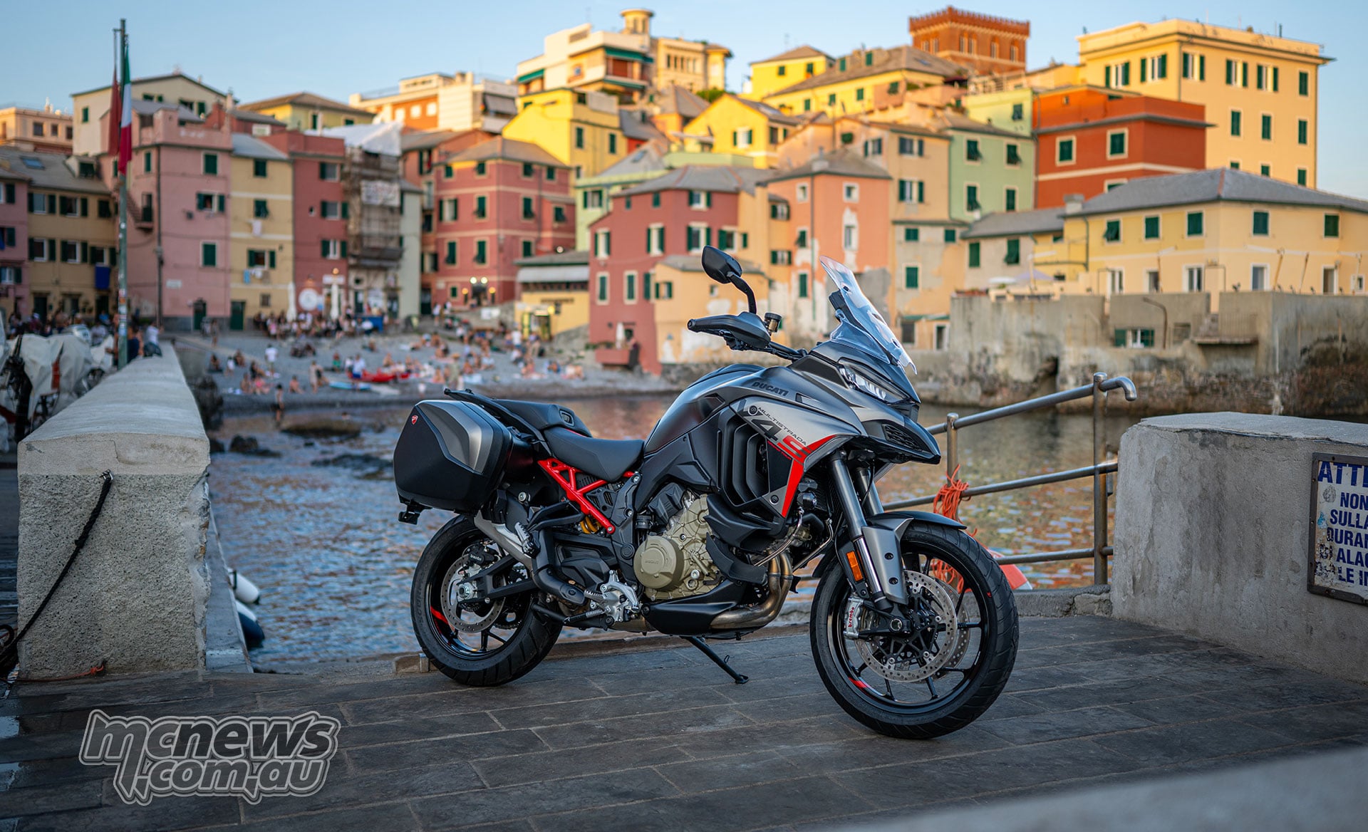 2027 Ducati Multistrada V4 S Grand Tour parked beside an Italian waterfront with side panniers fitted