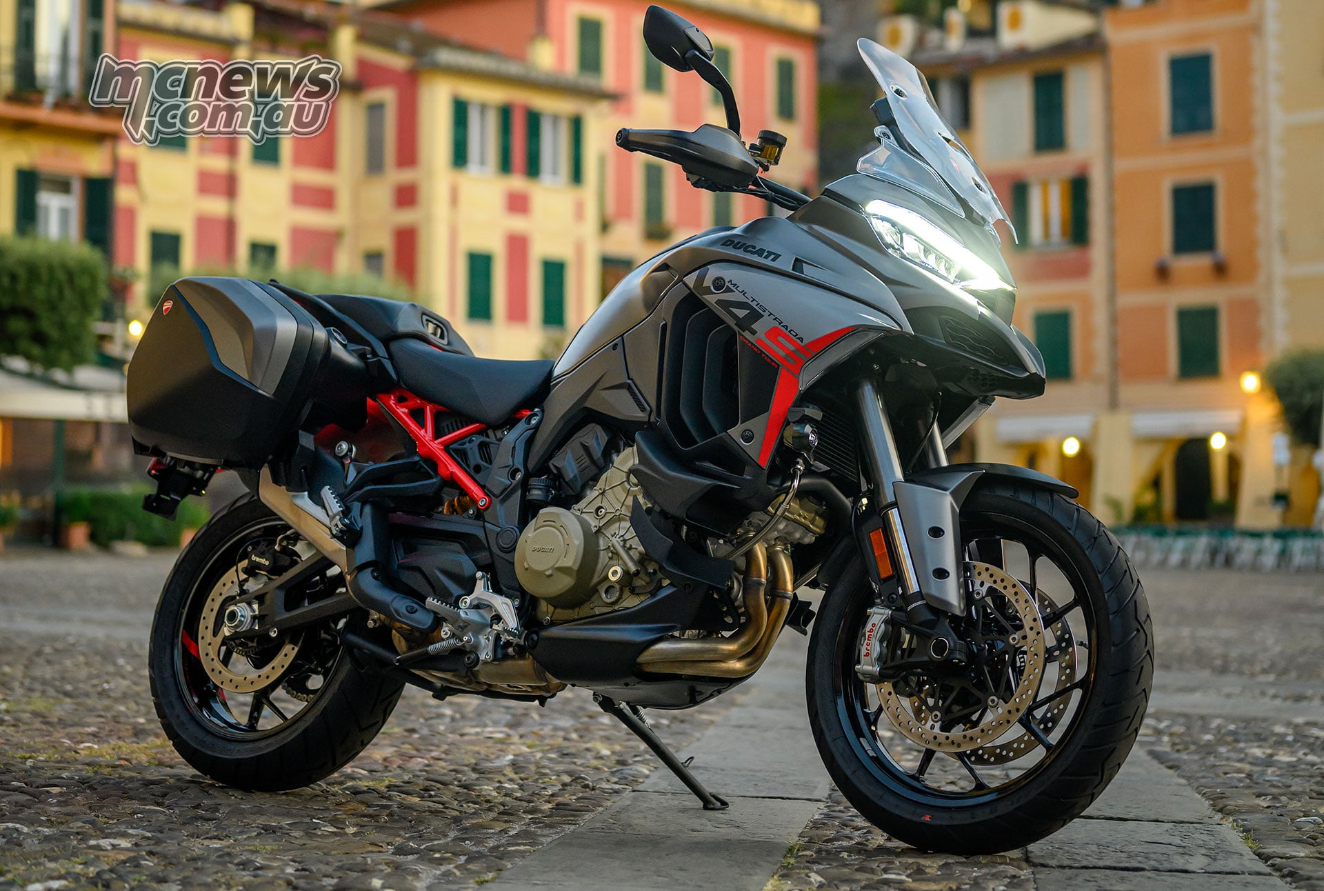 2027 Ducati Multistrada V4 S Grand Tour parked in an Italian town with panniers fitted