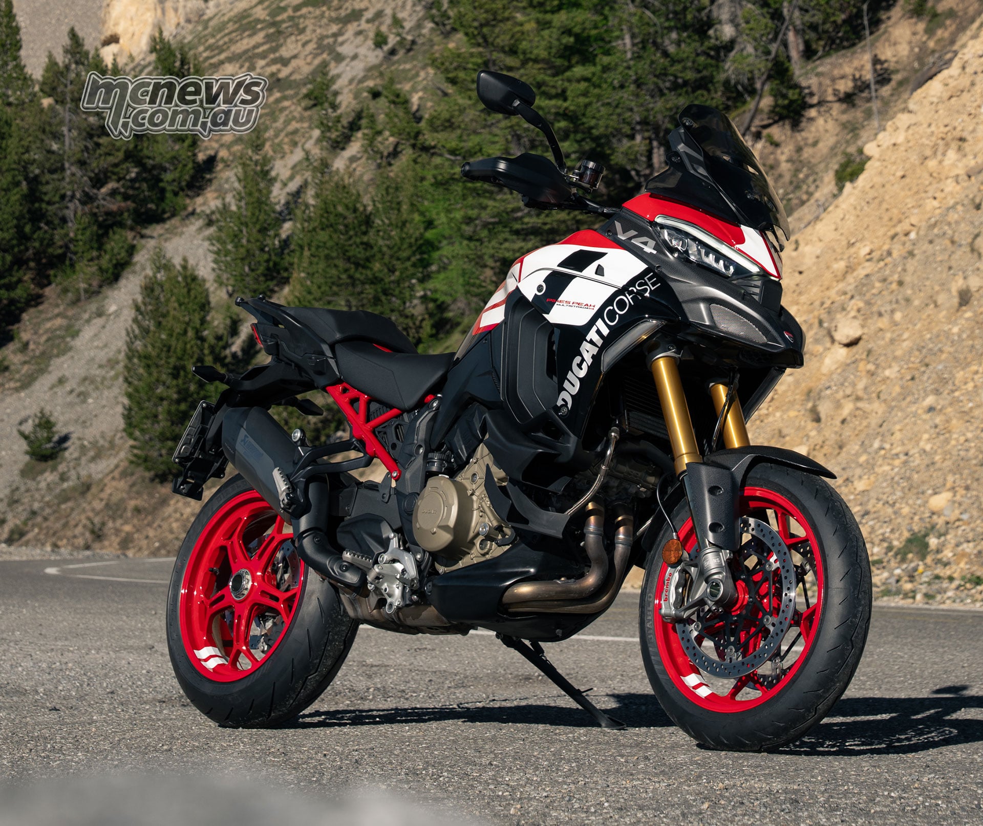 2027 Ducati Multistrada V4 Pikes Peak front three quarter view showing Ohlins suspension Brembo Stylema brakes and red wheels