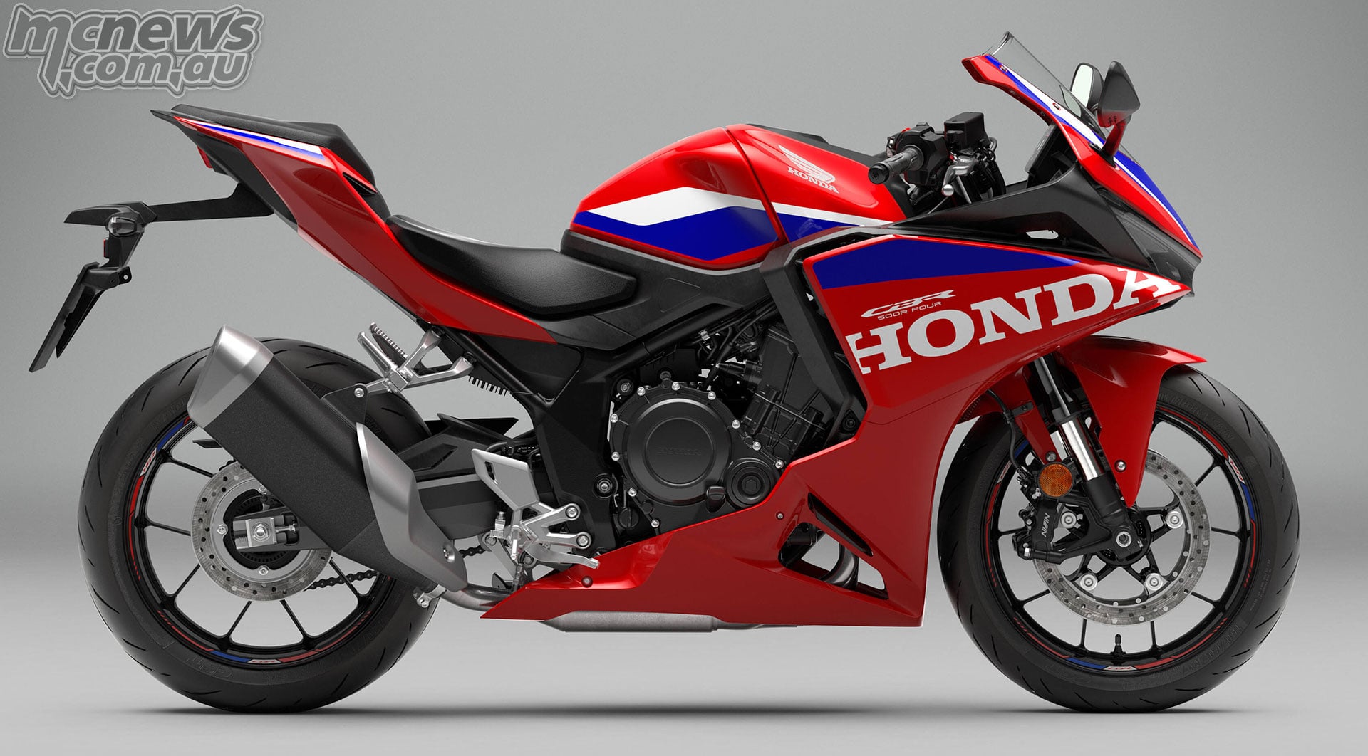 Full right-side studio profile of the 2027 Honda CBR500R FOUR in red, blue and white