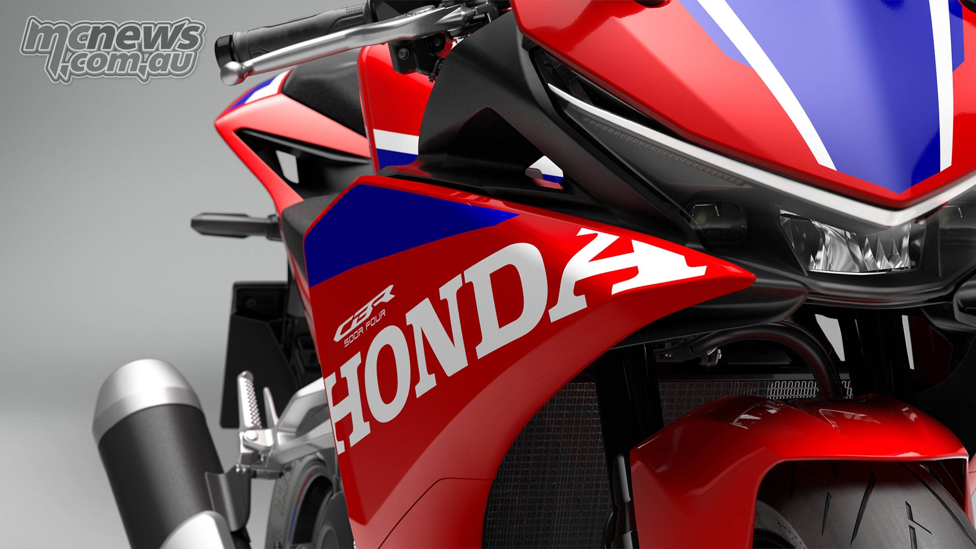 Close-up of the 2027 Honda CBR500R FOUR right front fairing with white Honda lettering and blue graphics