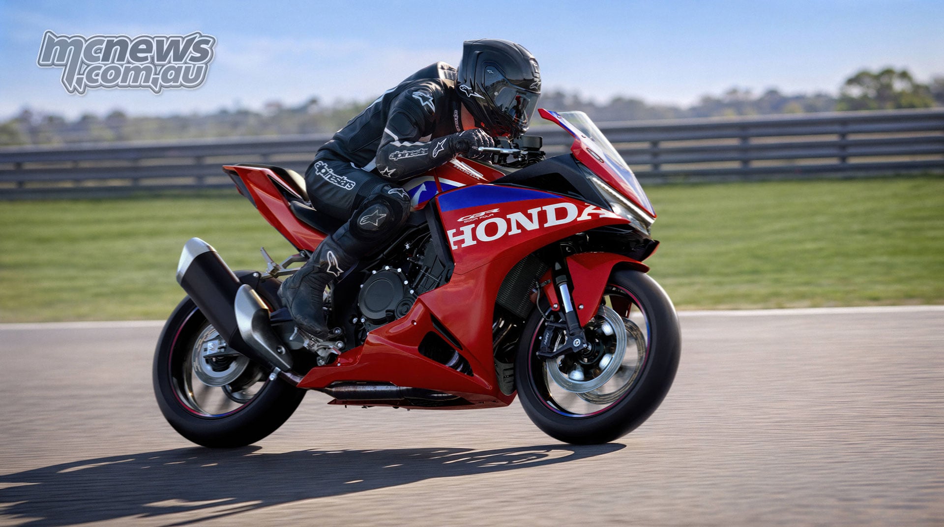 Rider on a red 2027 Honda CBR500R FOUR at a circuit, viewed from the right