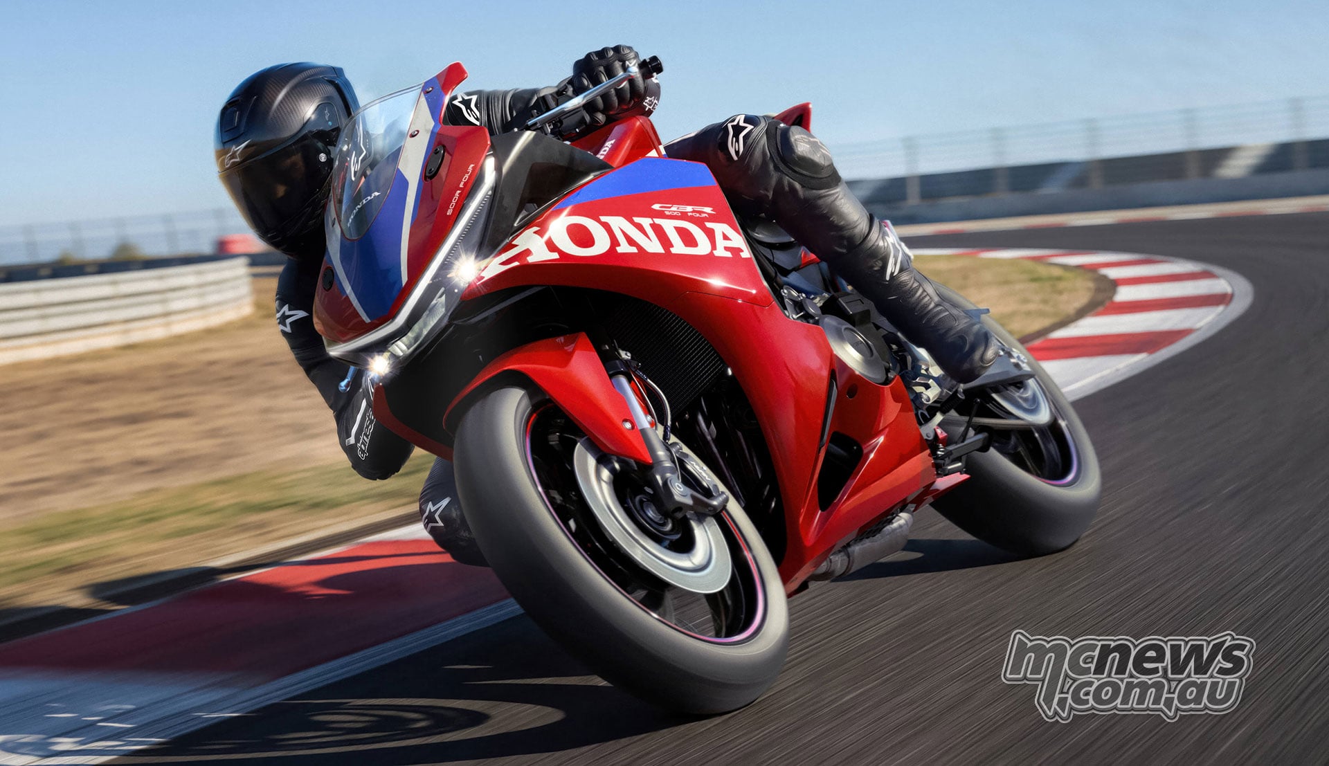 Front three-quarter action view of a rider cornering on the 2027 Honda CBR500R FOUR at a circuit