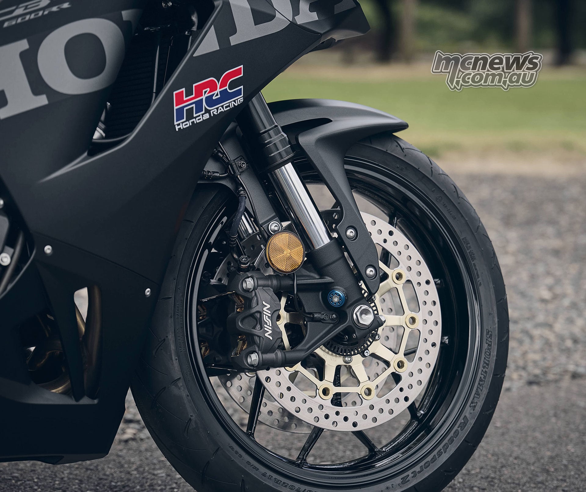 Close-up of the black 2027 Honda CBR600RR front wheel, Nissin brake caliper and Showa fork