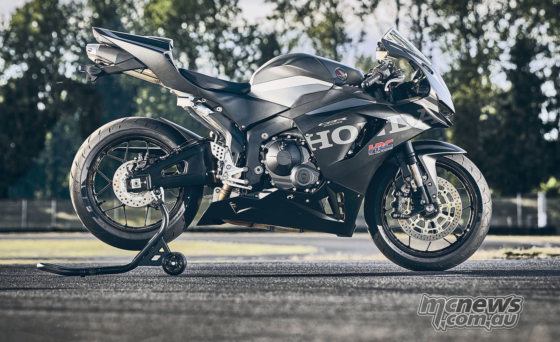 Full right-side view of the black 2027 Honda CBR600RR on a rear paddock stand outdoors