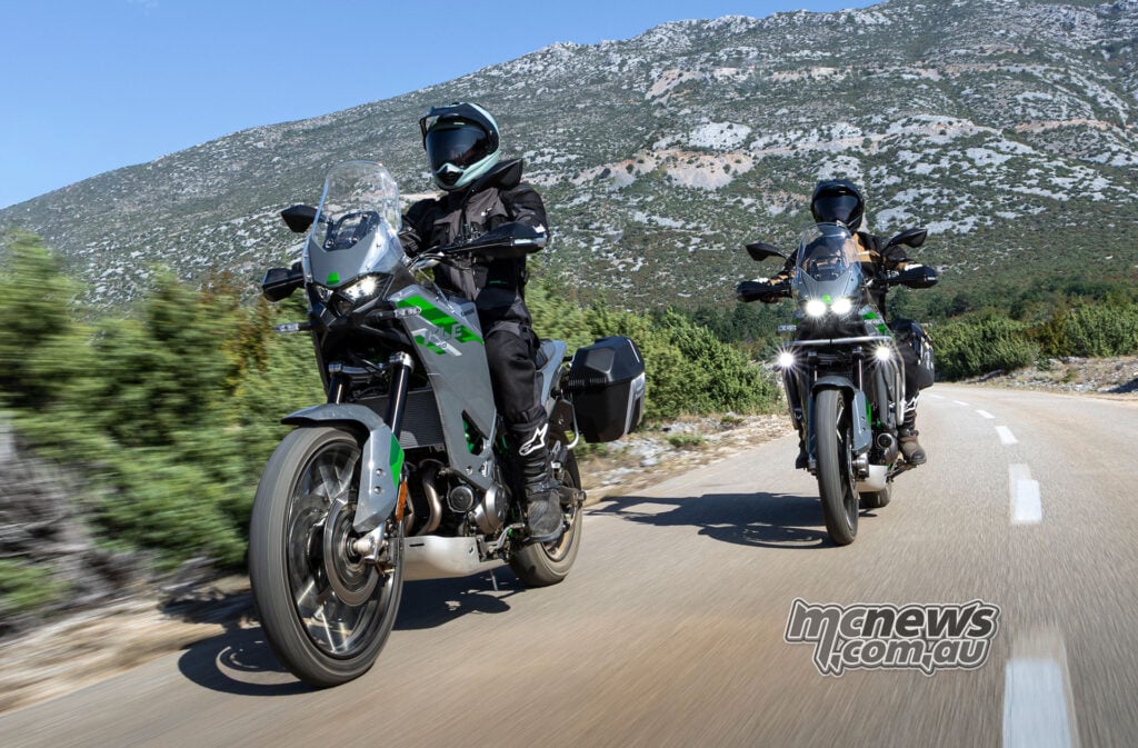 Two riders on Kawasaki KLE650 motorcycles with hard panniers travelling along a mountain road.