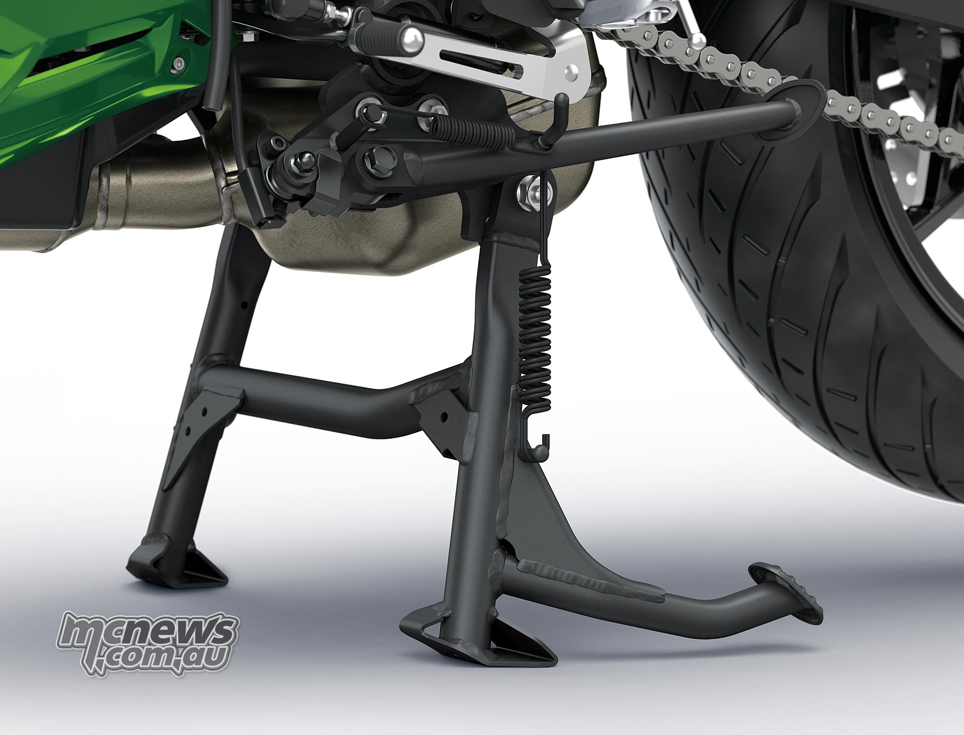 Deployed black centre stand beneath the Kawasaki Versys 900 SE beside the rear wheel and chain