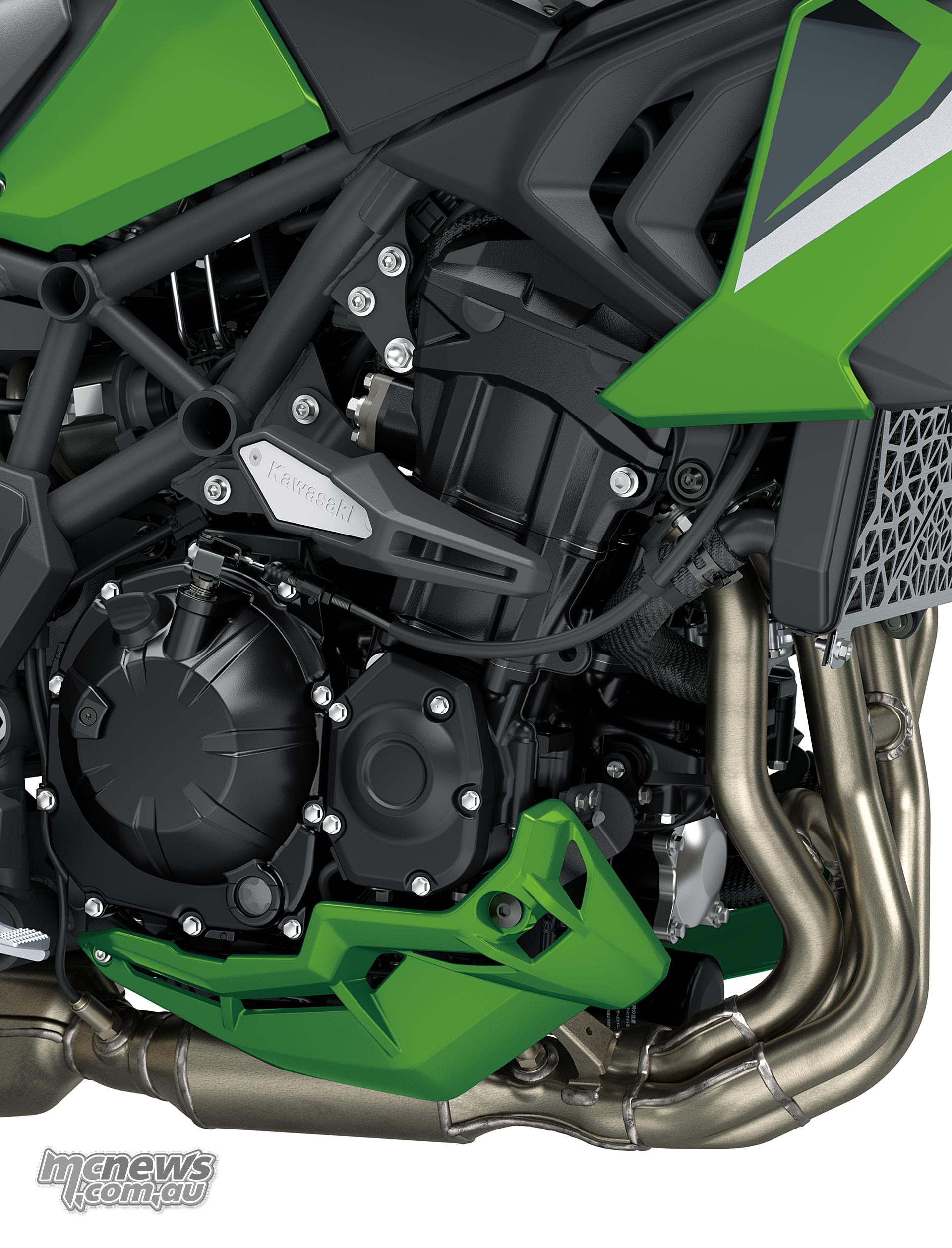 Kawasaki Versys 900 SE engine with four curved exhaust headers and a green lower cowl