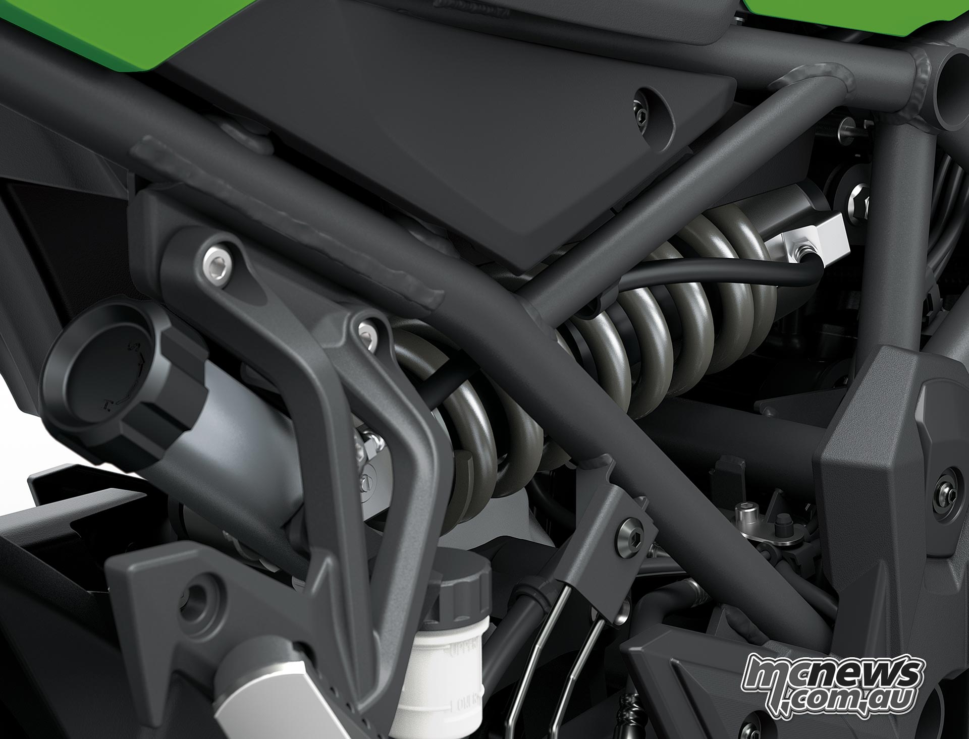 Horizontal rear shock and spring inside the Kawasaki Versys 900 SE trellis frame with the remote preload adjuster alongside