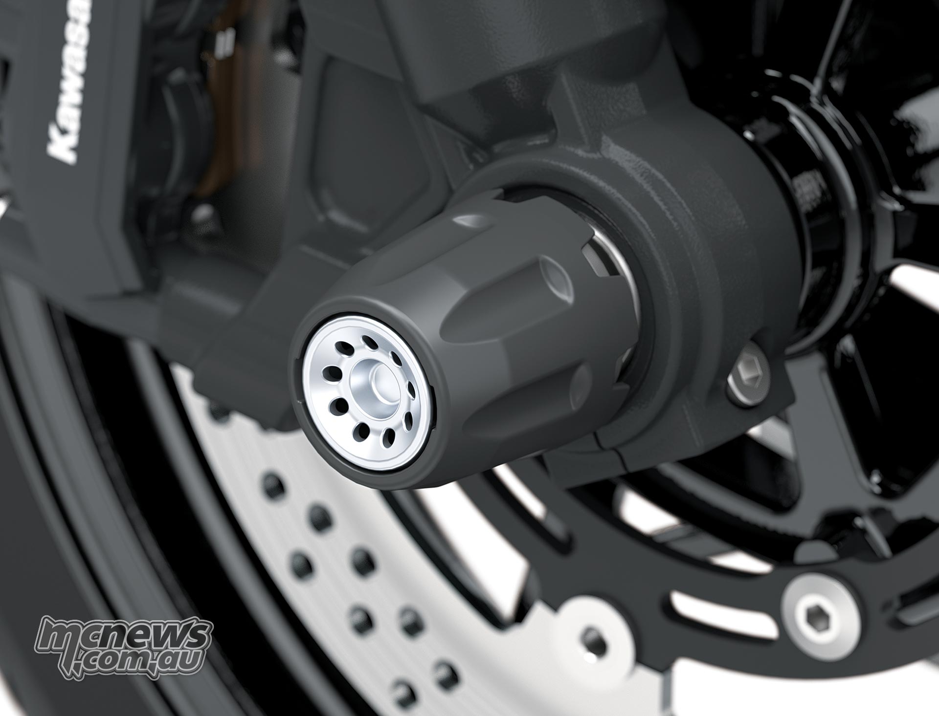 Cylindrical black front axle slider beside the Kawasaki Versys 900 SE fork leg and brake disc