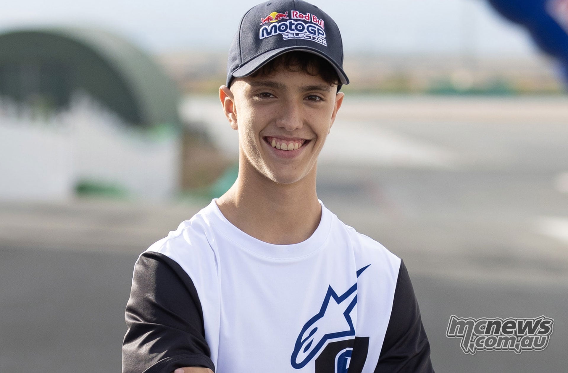 Italian rider Lorenzo Pritelli smiling in his Red Bull MotoGP Selection cap and Alpinestars shirt